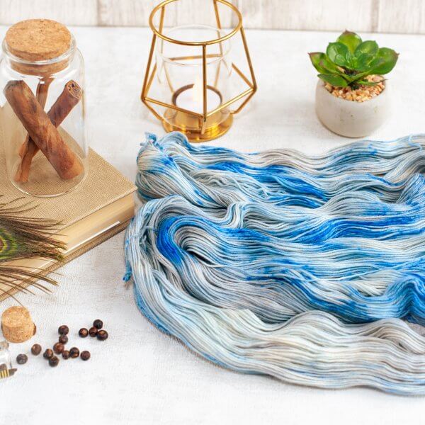 one skein of fingering weight silver yarn with blue speckles