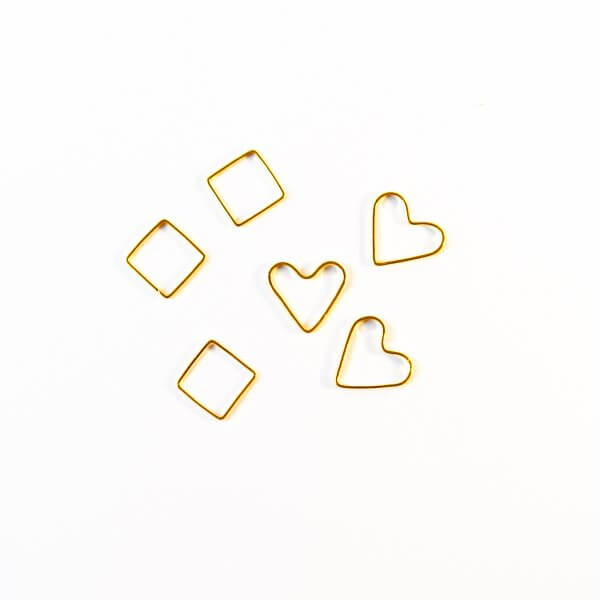 two square and two heart-shaped golden stitch markers